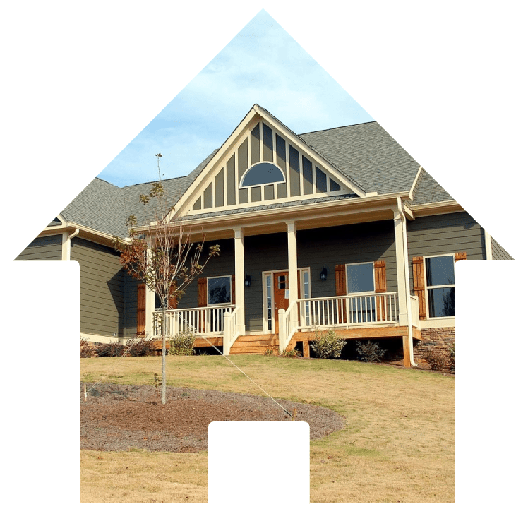 A house with a green roof and grass in front of it.