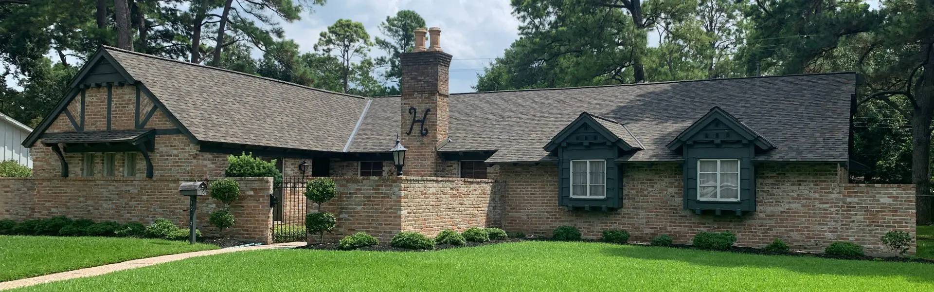 A brick house with a large stone chimney.