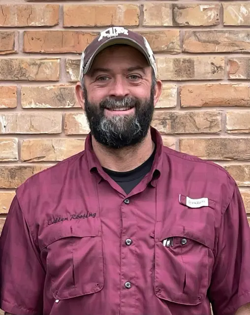 A man wearing a maroon shirt and hat.