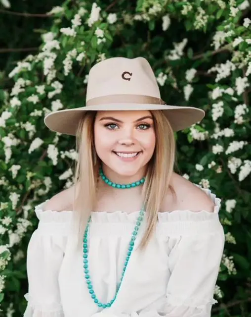 A woman wearing a hat and smiling for the camera.